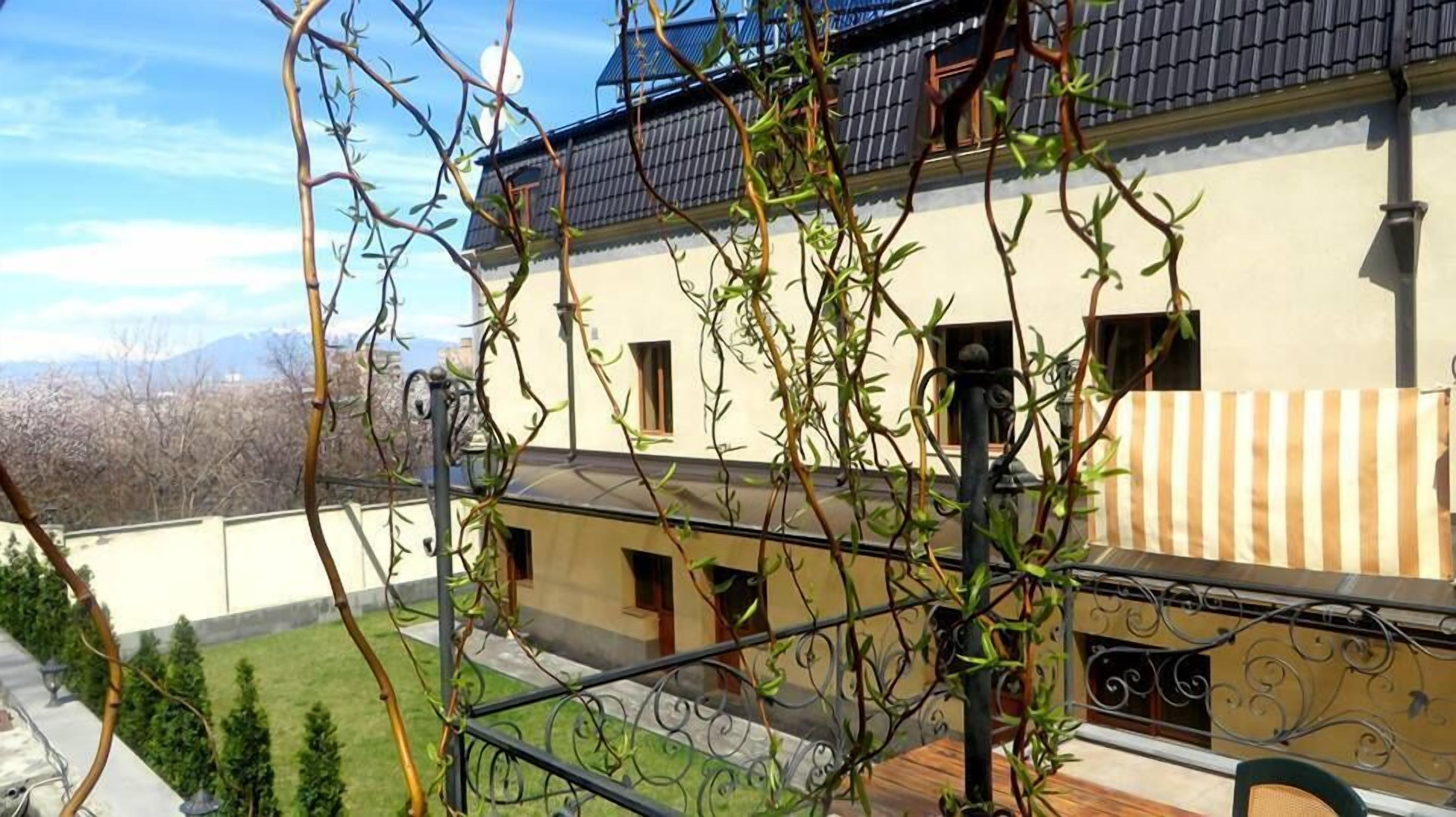 A building with a traditional architectural style, featuring a tiled roof and a balcony with a metal railing.