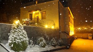 Paisaje nevado con una casa y un farol.