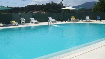 Piscine extérieure, parasols de plage, chaises longues