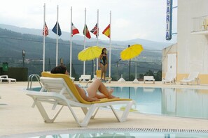 Piscine extérieure, parasols de plage, chaises longues