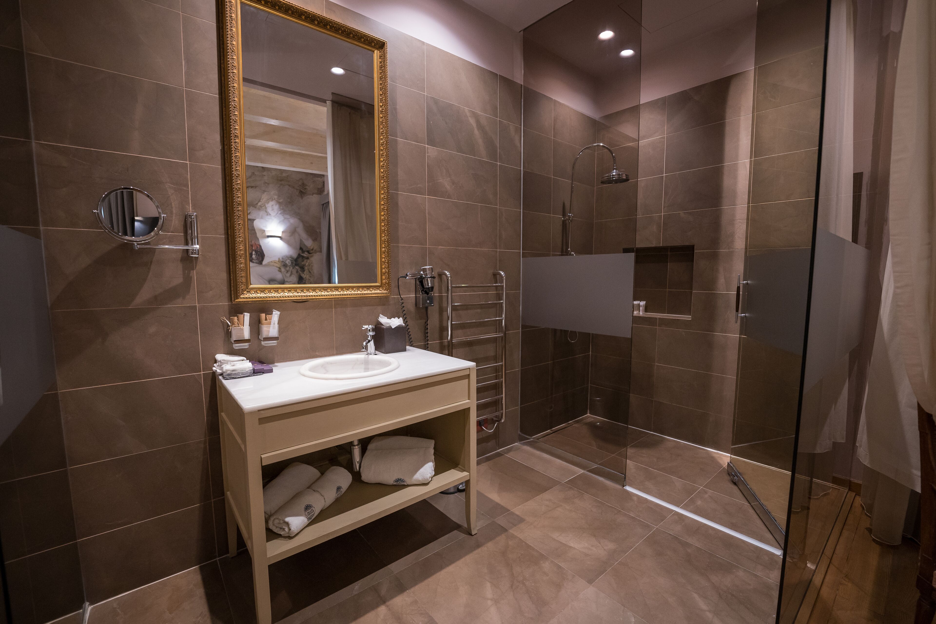 Une salle de bain moderne avec une douche à parois de verre, un meuble-lavabo avec un miroir et un porte-serviettes.