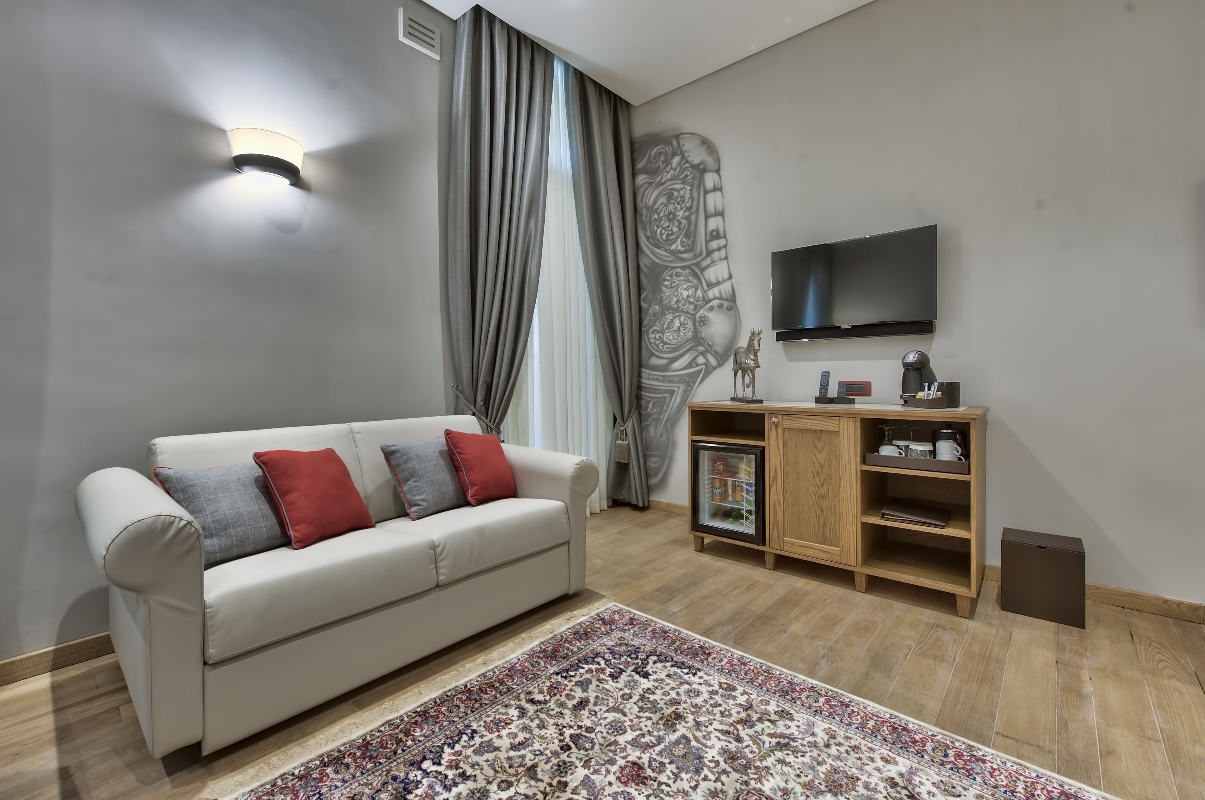 A living room with a sofa, a coffee table, a TV, a cabinet, and a patterned rug.