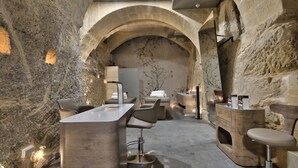 A spa area with stone walls, a reception desk, and multiple seating areas.