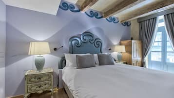 A bedroom with a large bed, two bedside tables, and a wardrobe.