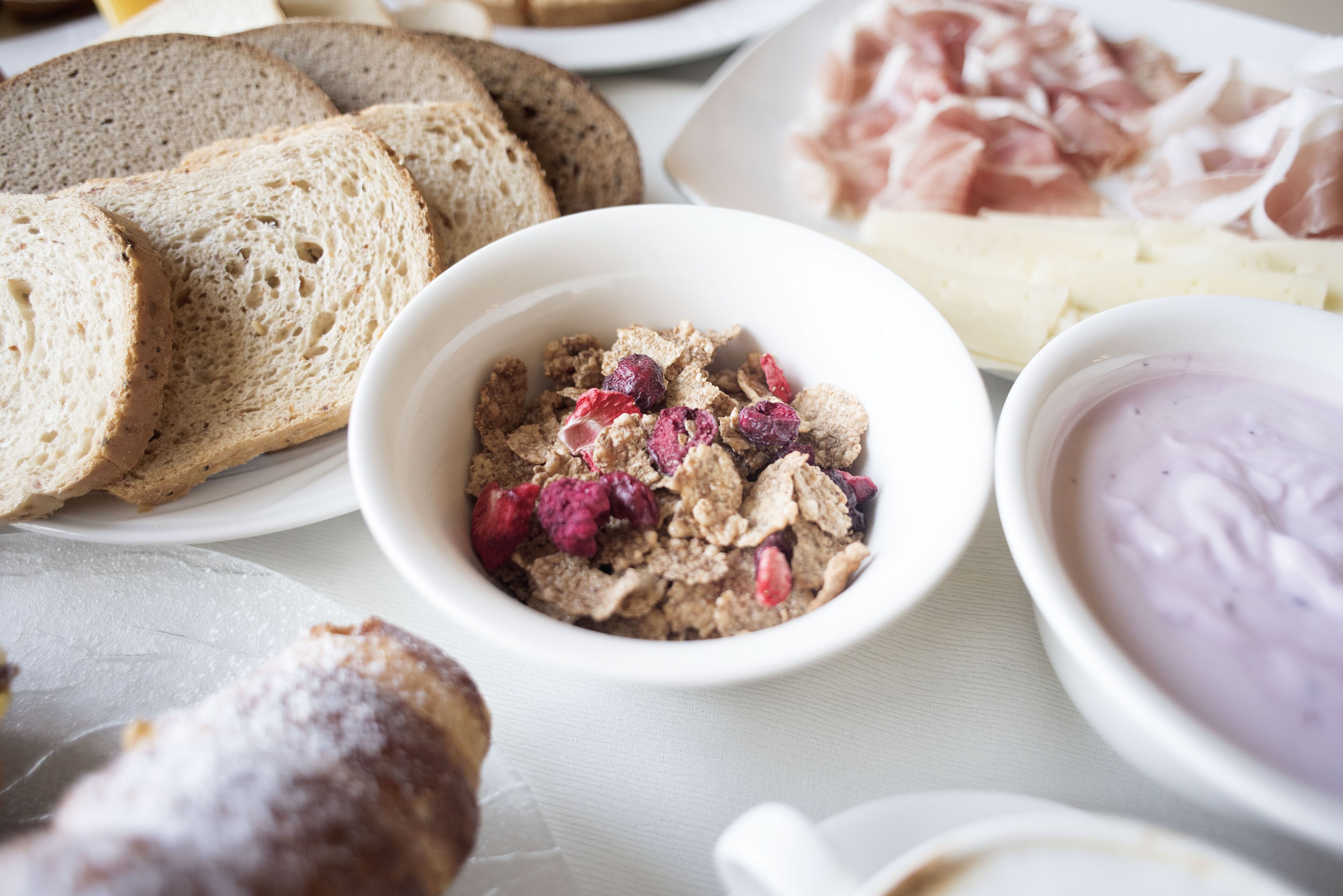 Verschiedene Speisen, darunter Brot, Getreide und eine Schüssel Joghurt.