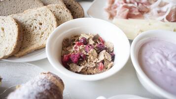 Verschiedene Speisen, darunter Brot, Getreide und eine Schüssel Joghurt.