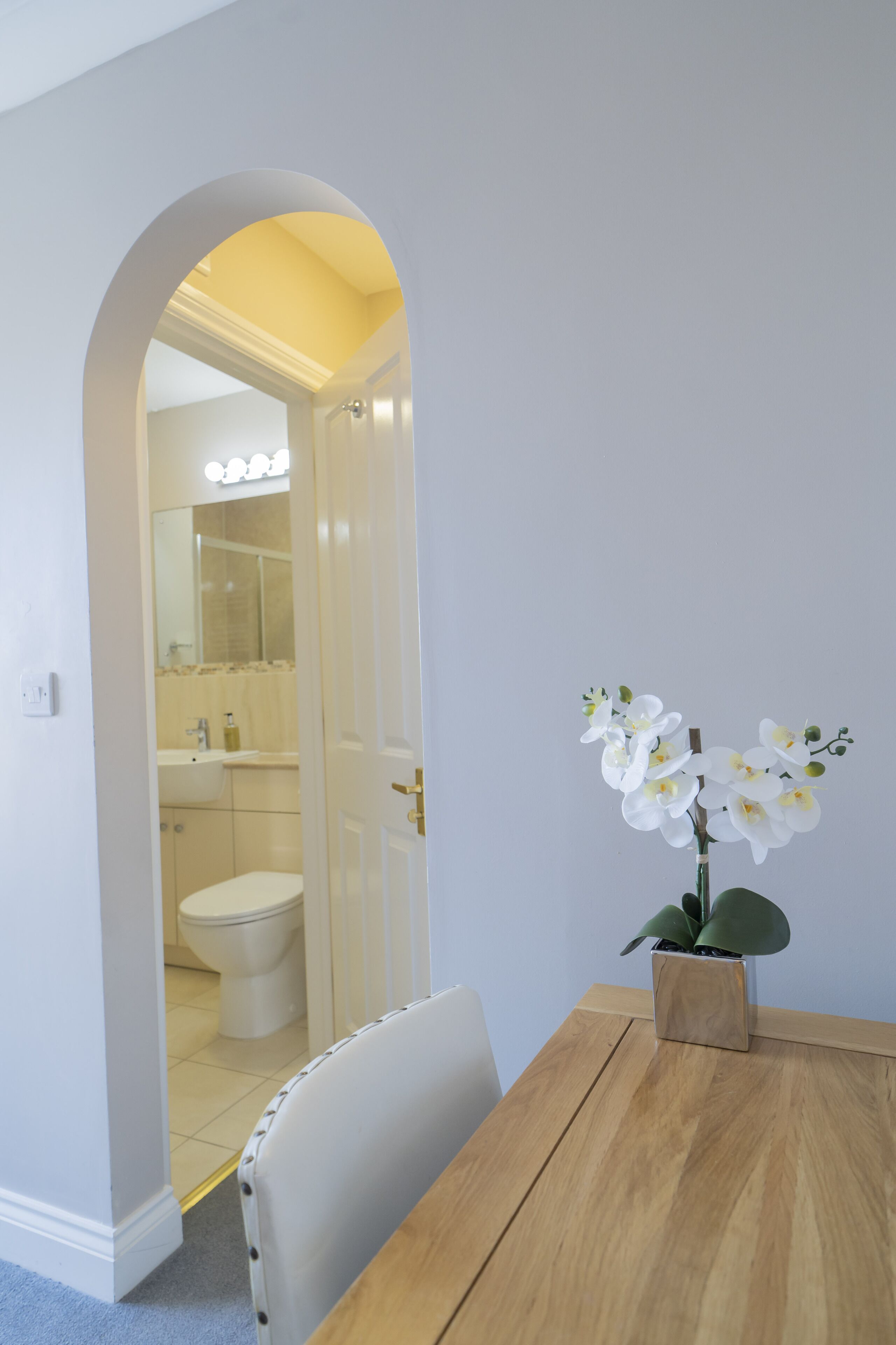 A bathroom with a toilet, sink, and mirror.