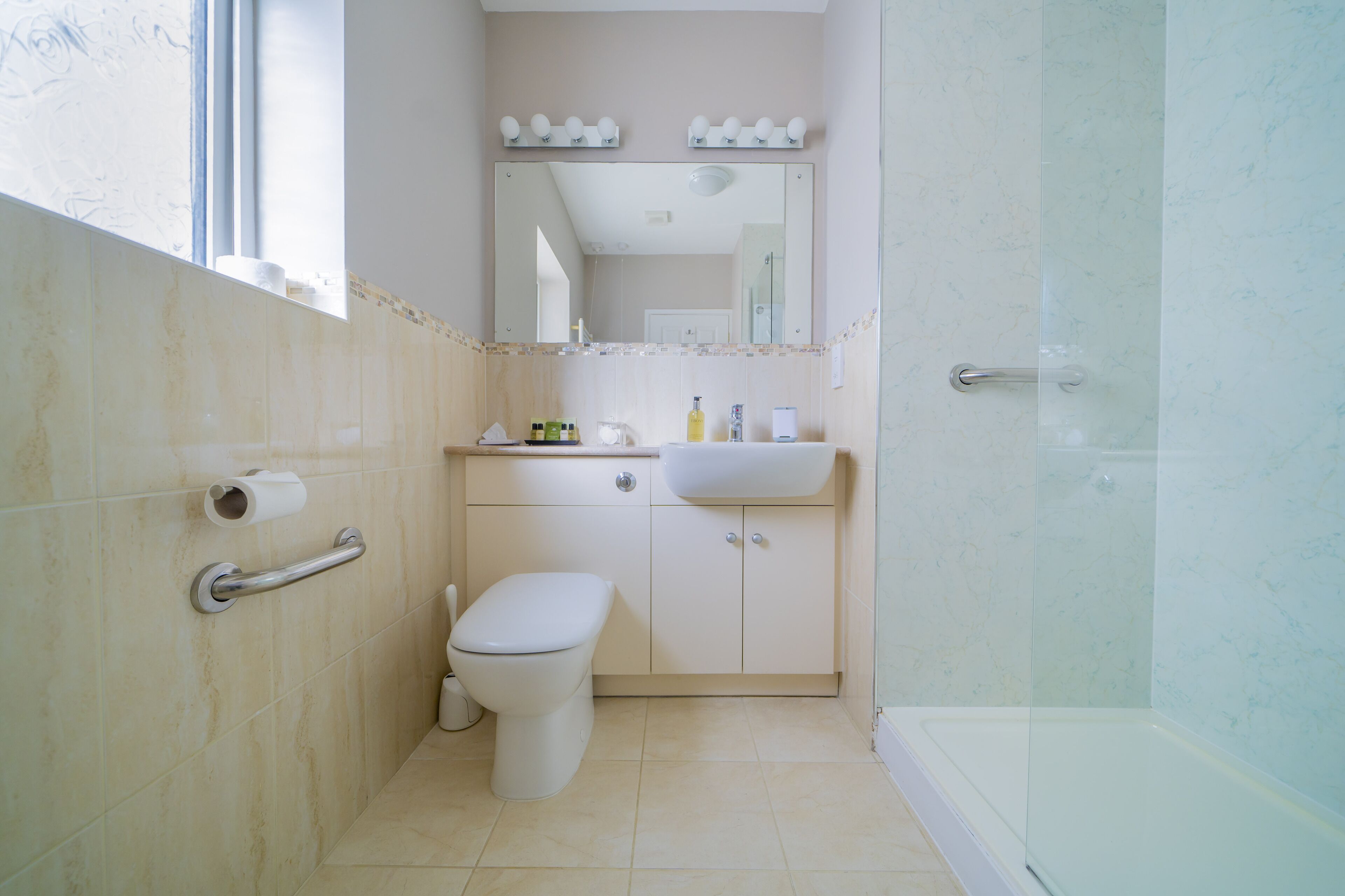A bathroom with a toilet, sink, and shower.