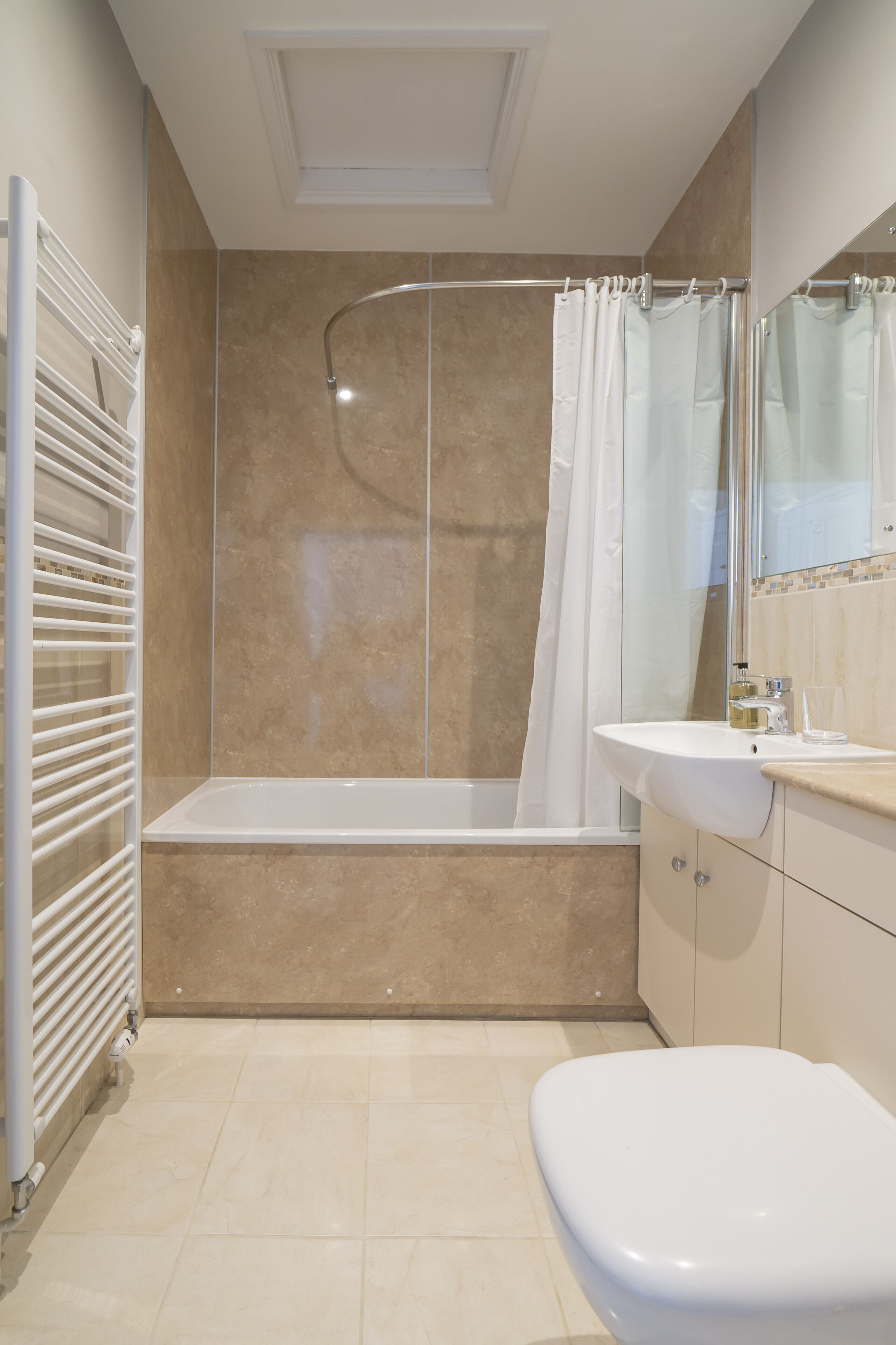Un baño moderno con bañera, ducha e inodoro.