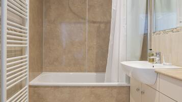 Un baño moderno con bañera, ducha e inodoro.