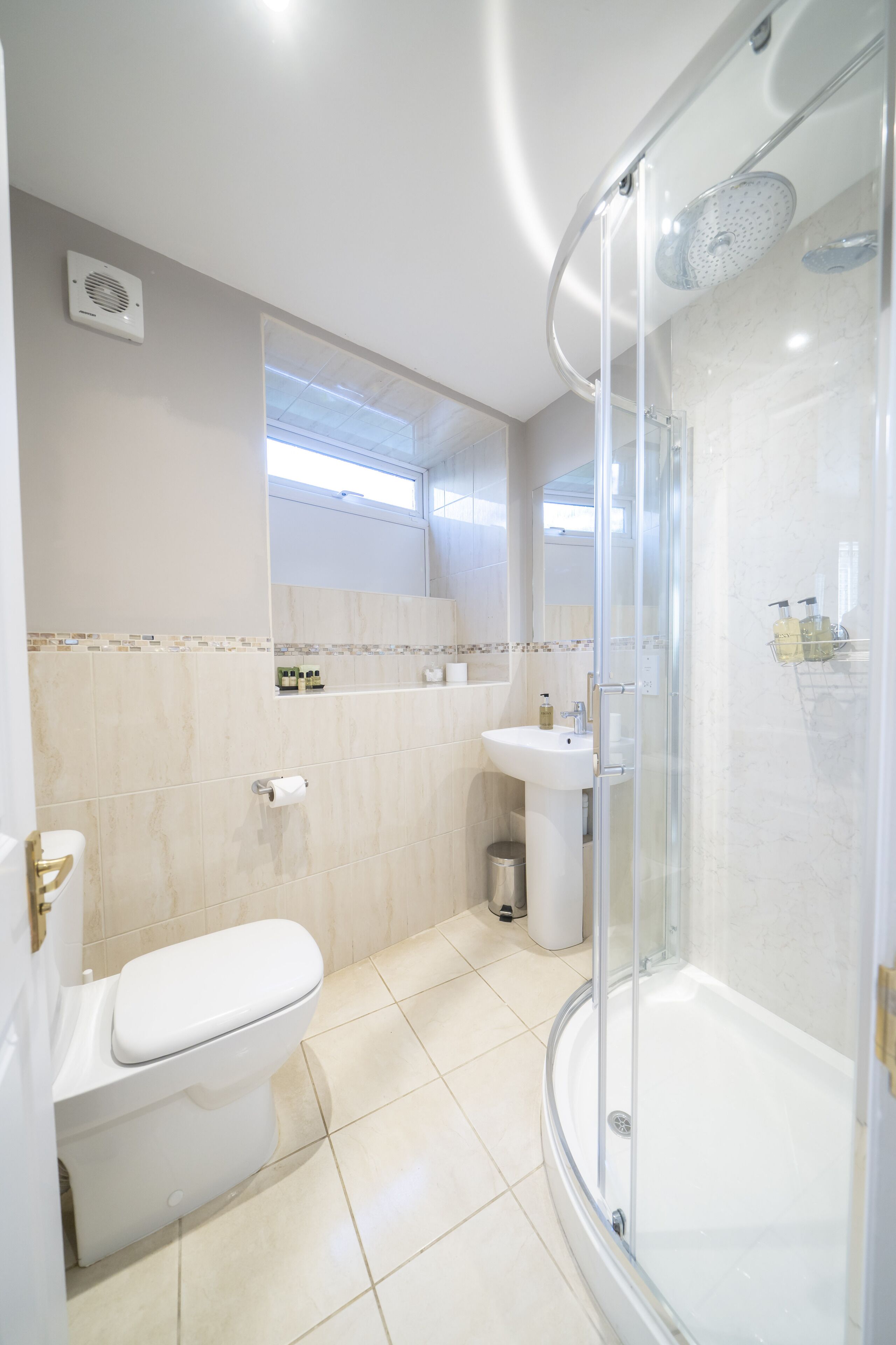 Une salle de bain moderne avec une douche à parois de verre, des toilettes et un lavabo.