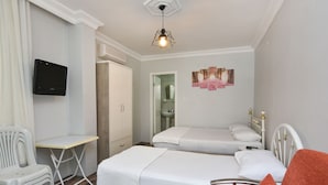 Un dormitorio con dos camas, un escritorio, una silla y un televisor.