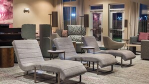 A hotel lobby with multiple seating areas, including sofas and armchairs, a piano, and a large wall-mounted screen. - Courtyard by Marriott Elmira Horseheads (Horseheads)