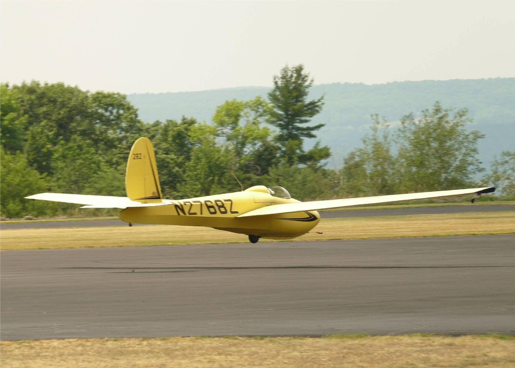 A yellow airplane with registration N27682Z on a runway.