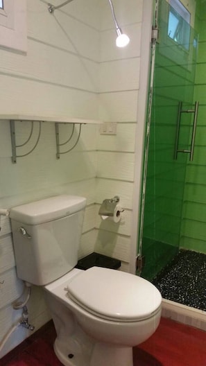 A bathroom with a toilet, a shower enclosure, and a toilet paper holder. - Ban Samlang (Hua Hin)