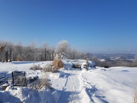 Paisaje nevado con un banco y una construcción de madera rústica.