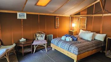 Een gezellige kamer met een houten bed, een stoel, een klein tafeltje en een radiator.