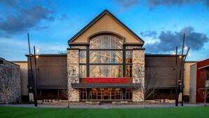 A modern building with a prominent 'Scheels' sign, featuring a stone facade and large glass windows. - Clarion Hotel The Colony - Plano West (The Colony)