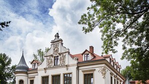 A historic building with a central tower, arched windows, and a symmetrical facade. - Pałac Polanka (Krosno)