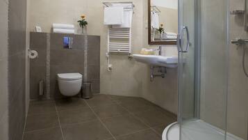 Un baño moderno con inodoro, lavamanos y ducha.