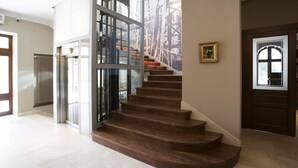 A modern staircase with wooden steps and glass railings, leading to a second floor. - Pałac Polanka (Krosno)