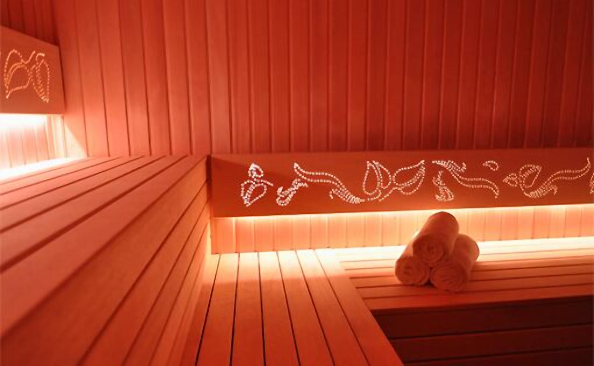 A wooden sauna with a bench and a towel rack.