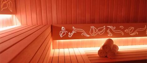 A wooden sauna with a bench and a towel rack.