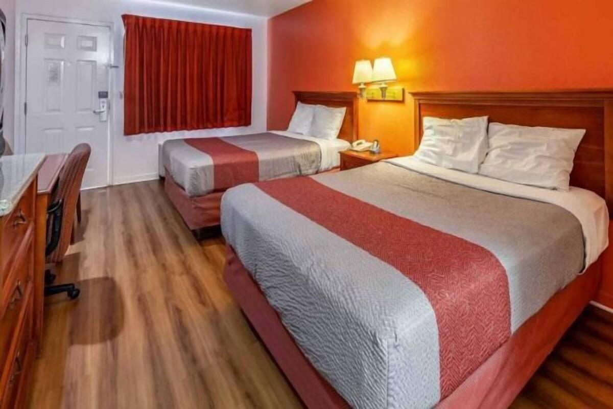 Una habitación de hotel con dos camas, un escritorio y una silla.