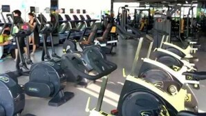 Un gimnasio con cintas de correr, máquinas de pesas y pesas libres.