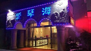 Fachada de edificio con señalización iluminada y arcos decorativos.