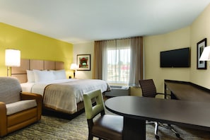 A hotel room with a bed, a desk, a chair, a lamp, and a TV. - Candlewood Suites Vestal - Binghamton by IHG (Vestal)