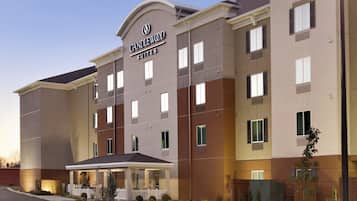A multi-story hotel with a prominent sign reading 'CANDLEWOOD SUITES'.