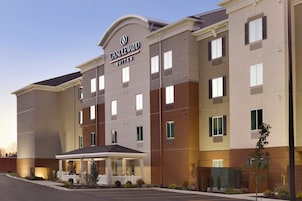 Un hotel de varios pisos con un letrero llamativo que dice 'CANDLEWOOD SUITES'.