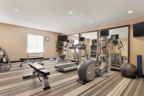 Ein Fitnessstudio mit Laufbändern, Crosstrainern und Gewichtsmaschinen.
