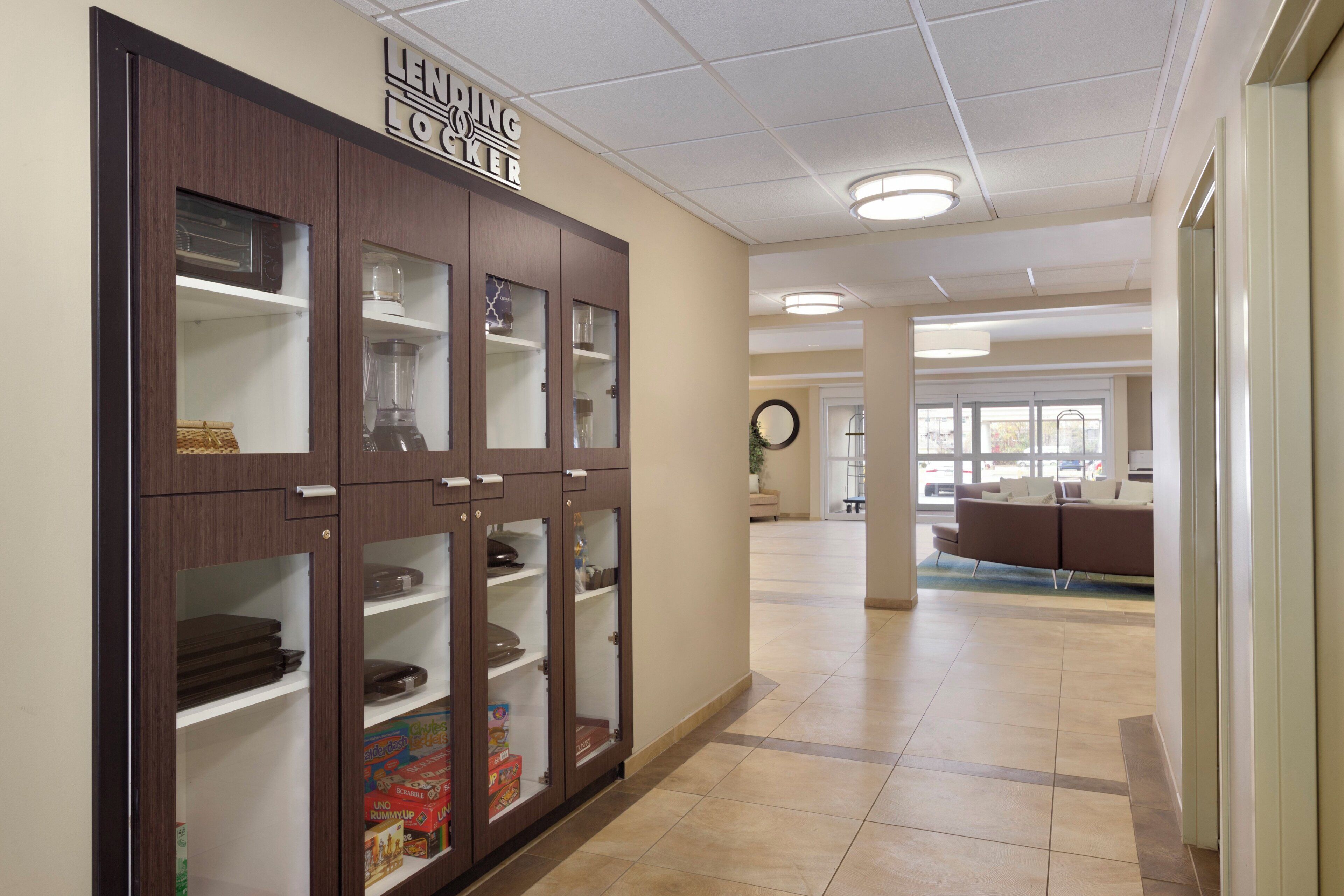 A hallway with a wooden cabinet labeled 'LENDING LOCKET' containing various items.