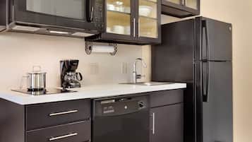 A modern kitchen with a black refrigerator, a coffee maker, and a microwave.