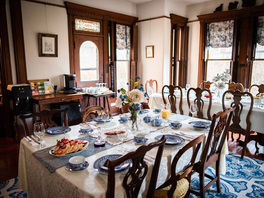 A dining area with a table set for a meal, surrounded by wooden chairs.