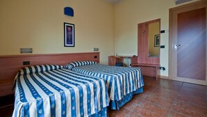 A room with two beds, a desk, a chair, a mirror, and a door. - Hotel Blue Ribbon (Vercelli)