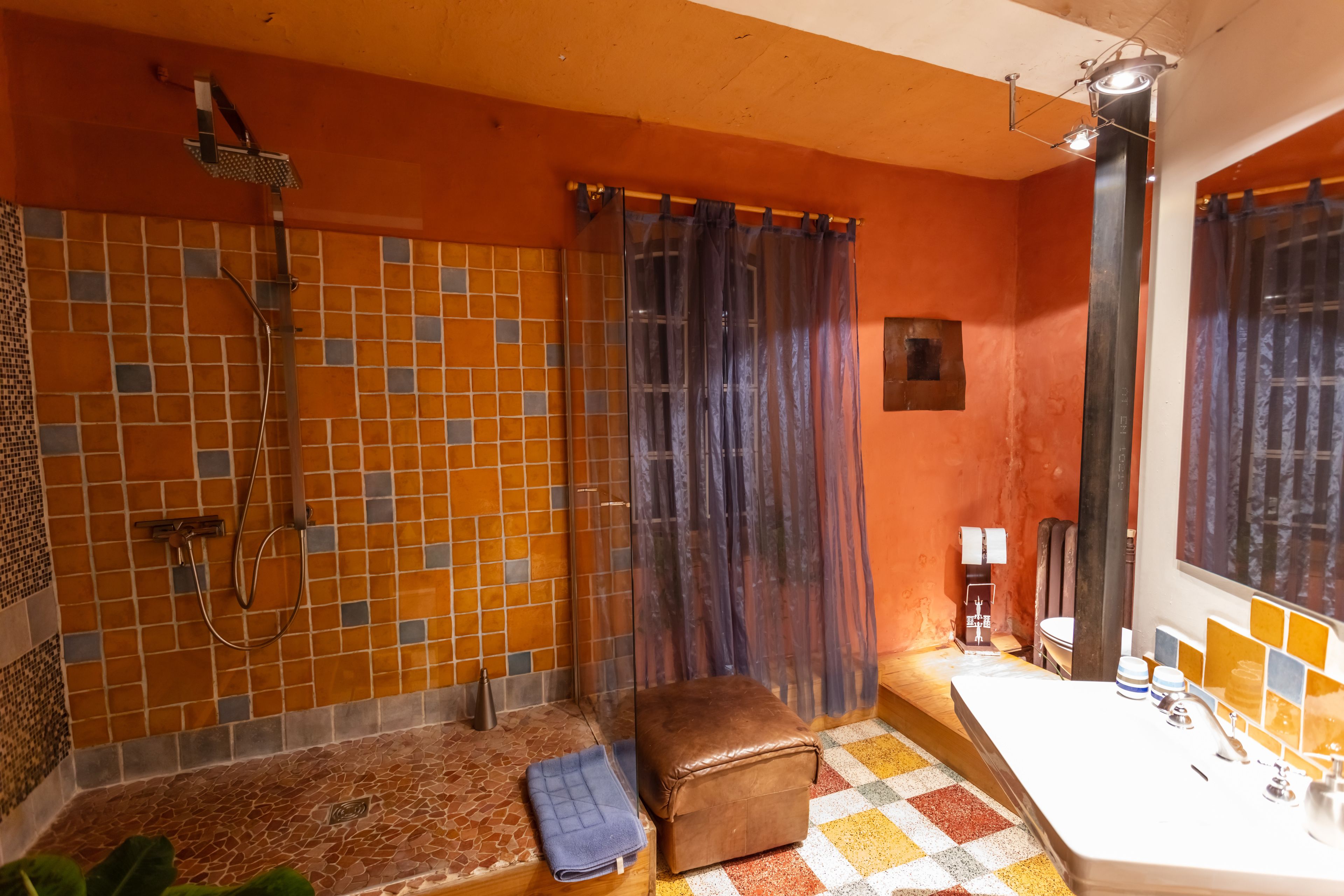 A bathroom with a tiled shower, a bathtub, a toilet, and a sink.