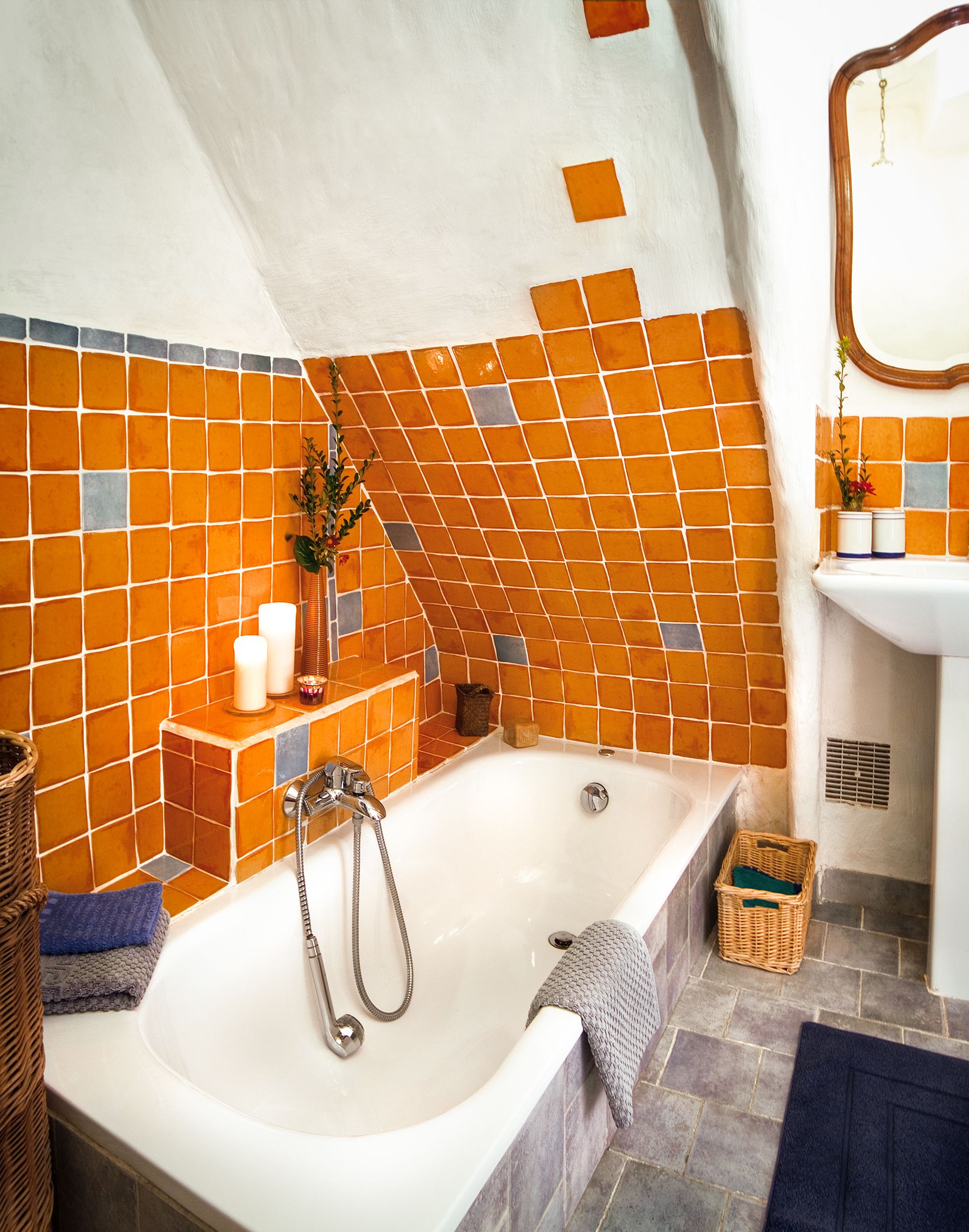 Een badkamer met een groot bad, betegelde wanden, een wastafel en een spiegel.