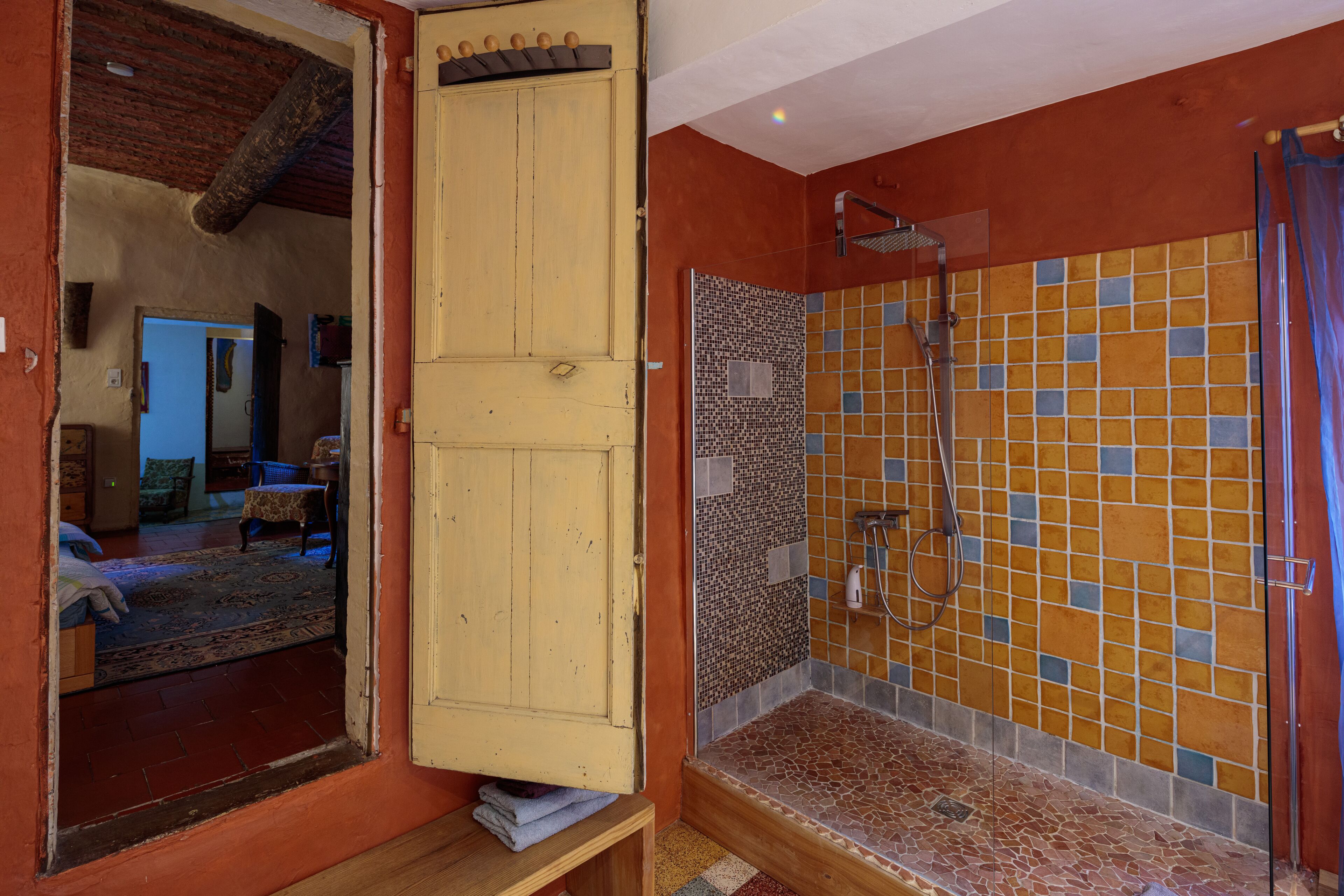 Un baño con ducha, paredes de azulejos y una puerta de madera.