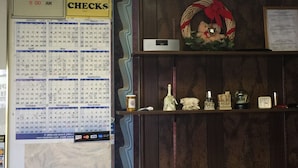 Una pared con un calendario, un reloj y un certificado de reconocimiento.