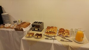 A breakfast buffet with various pastries, bread, and a toaster. - Hotel Avenida (Buenos Aires)