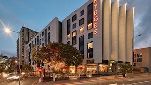 A modern hotel with a prominent "RYDGES" sign, featuring a clean architectural design with multiple floors and large windows. - Rydges Fortitude Valley (Bowen Hills)