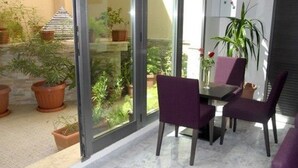 Ein moderner Essbereich mit Glastrennwand, einem Tisch und violetten Stühlen.
