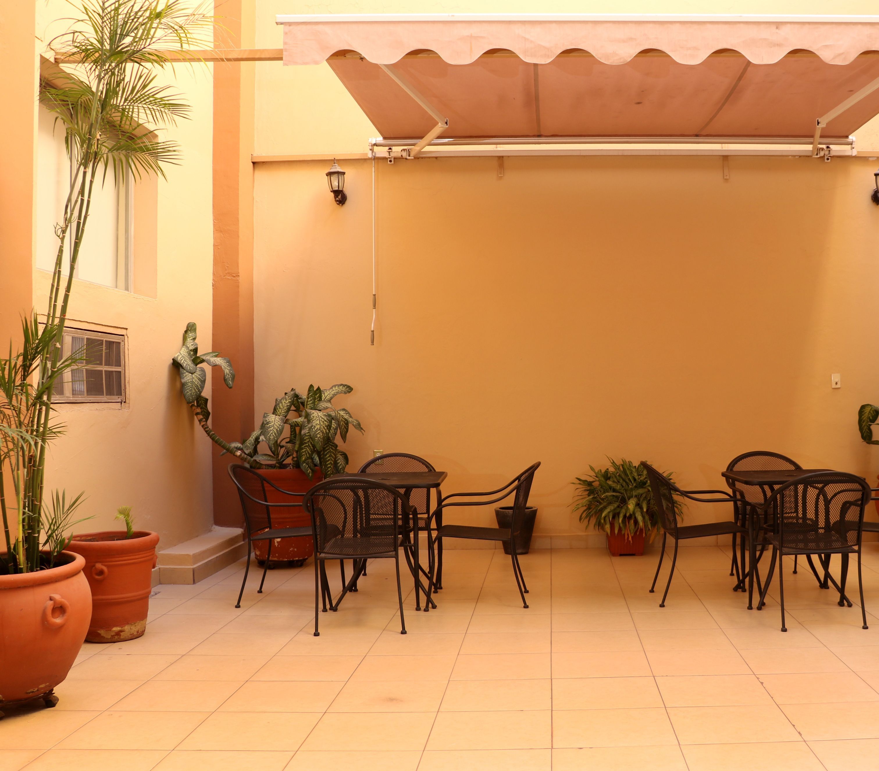 A patio with outdoor furniture and potted plants.