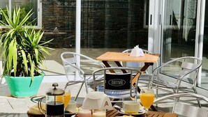 A breakfast setup with a coffee maker, orange juice, and various breakfast items on a wooden table. - Hotel Azul Puerto Punta del Este (Punta del Este)