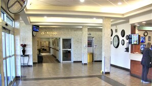 A hotel lobby with a reception desk, a clock, and a sign for a games room. - Continental Inn & Suites (Edmonton)