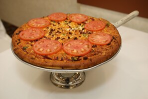 Una pizza sobre un soporte metálico.