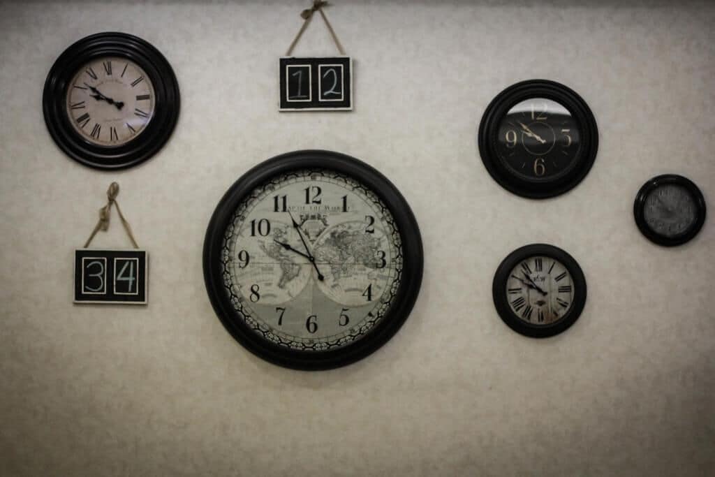 Un mur orné de cinq horloges de styles et de tailles différents.